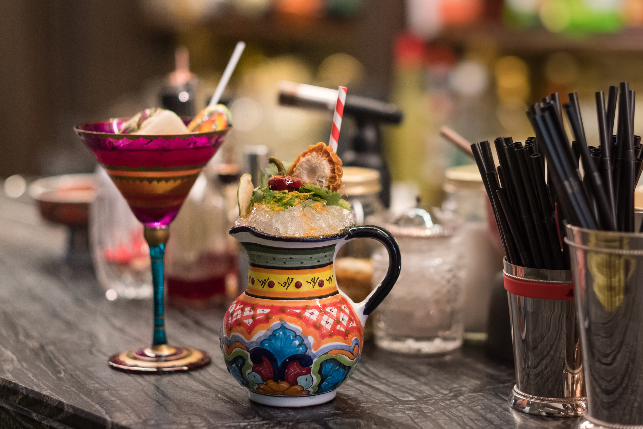 colorful martini with cup and straws on bar