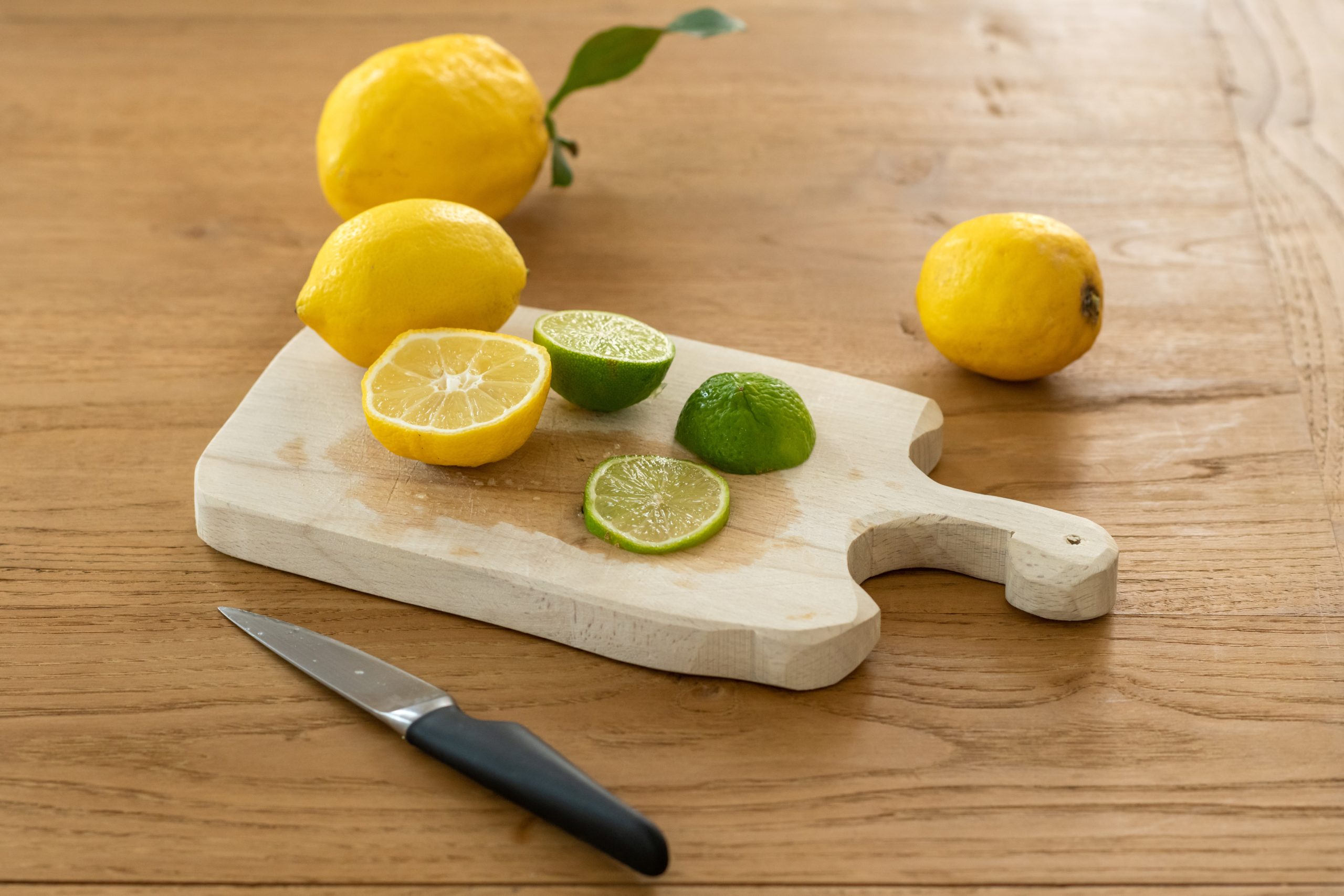 cutting board with knife lemons and lime