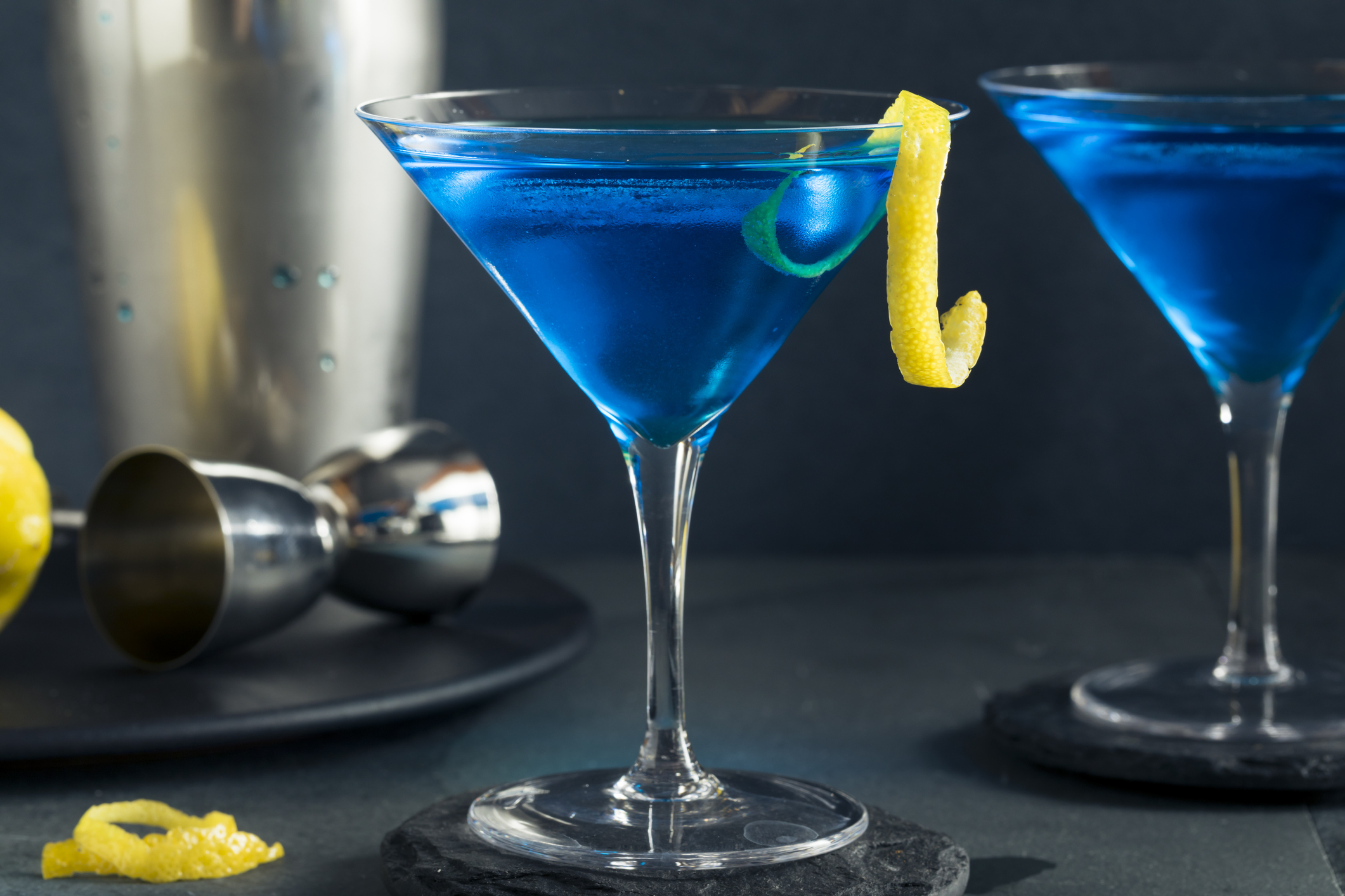 two blue martinis with lemon peel